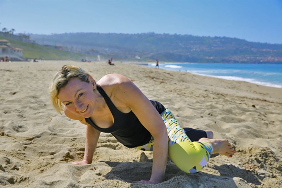 LIsa in a yoga pose on the beach